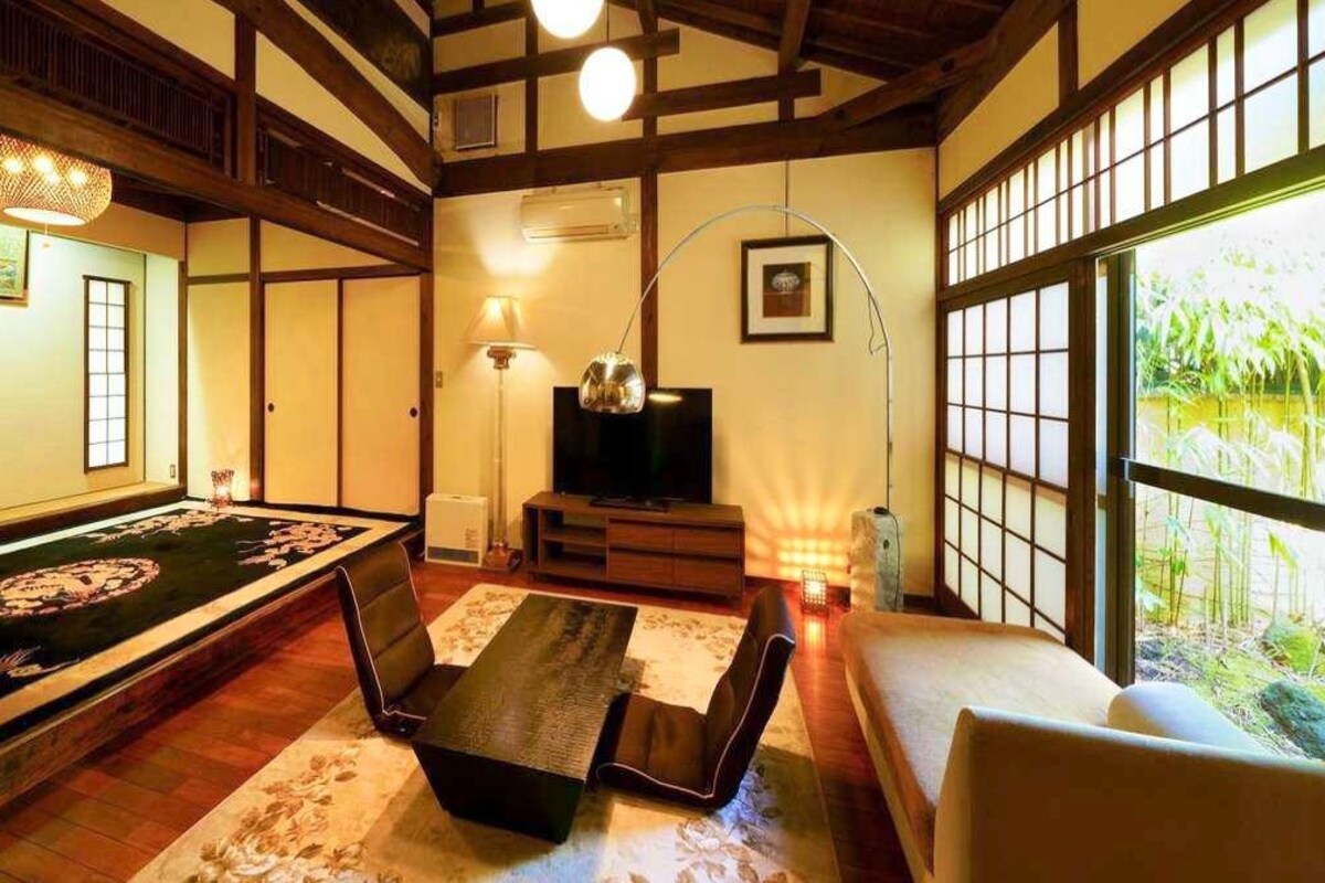 A traditional Japanese room with tatami flooring, a low table, and a sofa.
