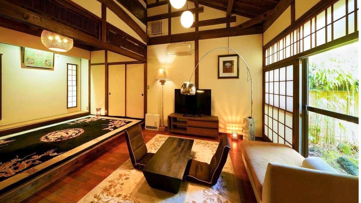 Une pièce de style japonais traditionnel, avec un sol recouvert de tatamis, une table basse et un canapé.