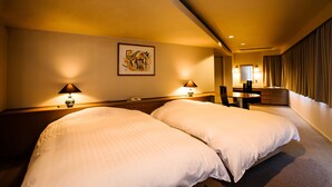 A hotel room with two beds, a desk, a chair, and a small table. - Hotel Zaaz (Oita)