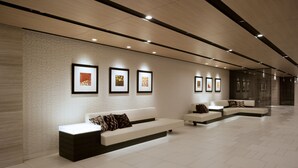 A modern waiting area with a long bench, a sofa, and framed artwork on the wall. - Miyako City Kintetsu Kyoto Station (Kyoto)