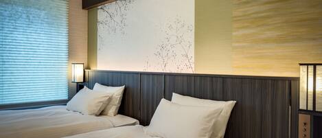 Une chambre d’hôtel avec deux lits, une grande fresque murale et un design moderne.