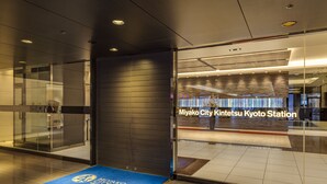 A modern train station entrance with glass doors and a blue mat with text. - Miyako City Kintetsu Kyoto Station (Kyoto)