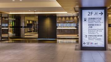 A modern interior with a sign directing to the Kintetsu Line and Shinkansen Central Entrance.