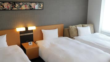 Una habitación de hotel con dos camas, una mesita de noche con lámpara y un adorno en la pared.