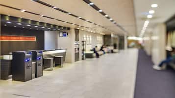 A modern indoor space with a reception desk, a waiting area, and a clean, tiled floor.