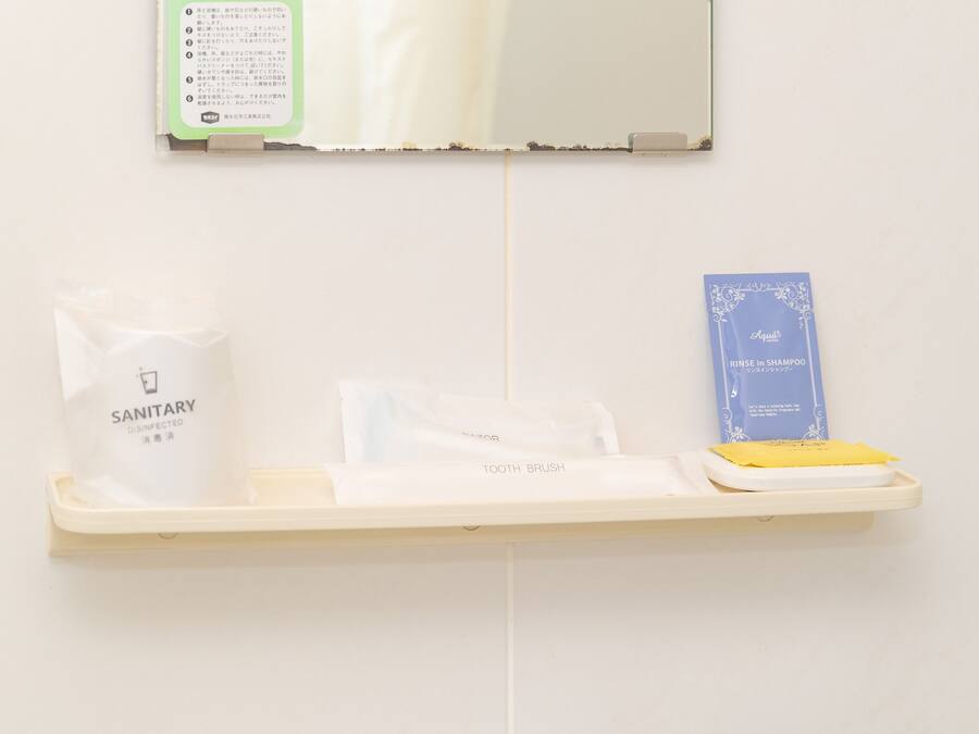 Ein Badezimmerschrank mit einem Hygienebeutel, einer Zahnbürste und einer blauen Schachtel mit japanischen Schriftzeichen.