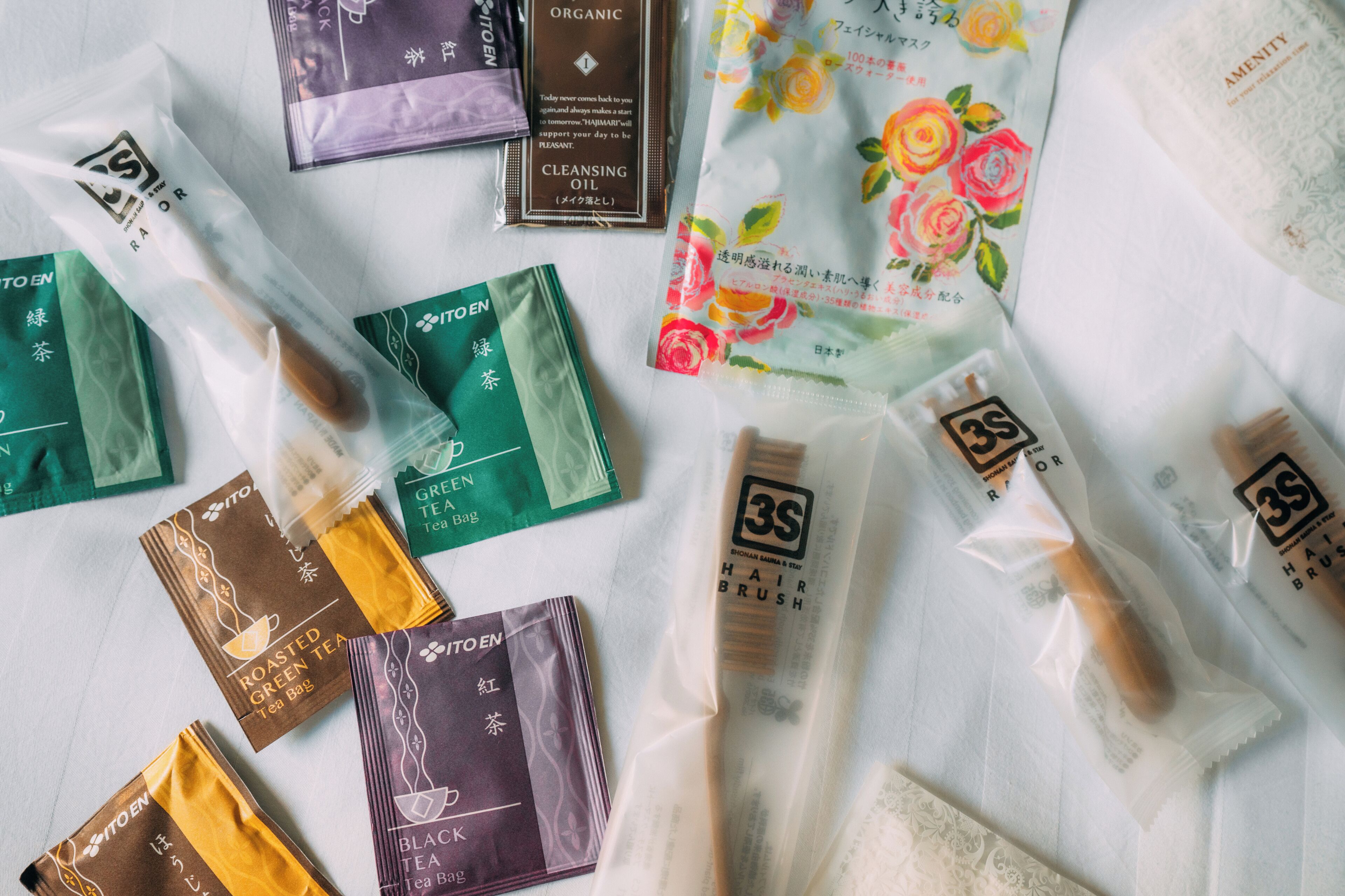 Various packaged items including tea bags and a hair brush, arranged on a table.