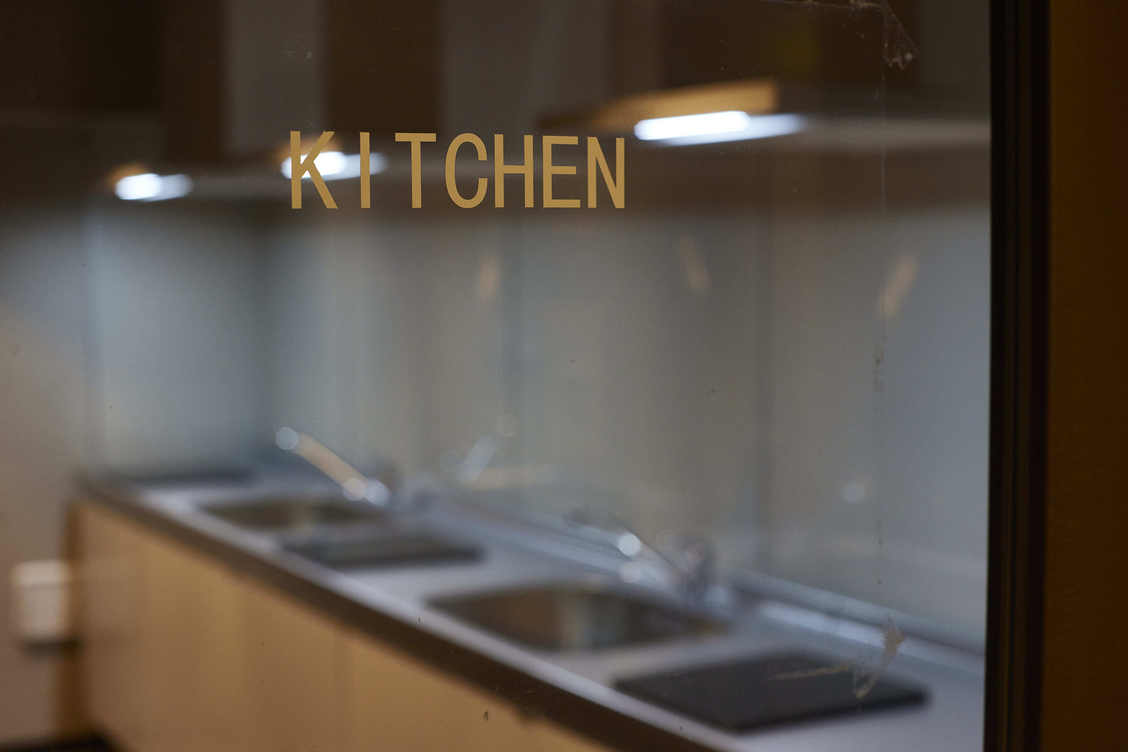 Una encimera de cocina con un lavamanos y una ventana que muestra el texto 