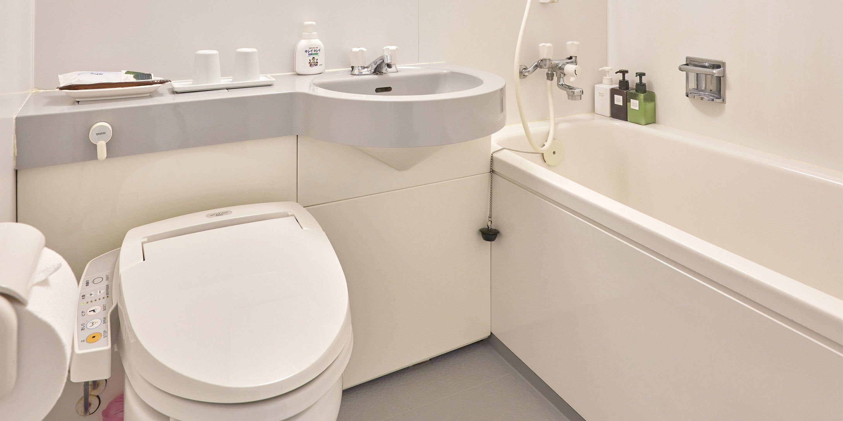 A modern bathroom with a toilet, sink, and bathtub.