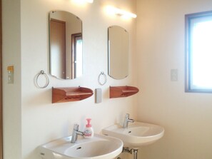 Ein Badezimmer mit zwei Waschbecken, einem Spiegel und einem Fenster.