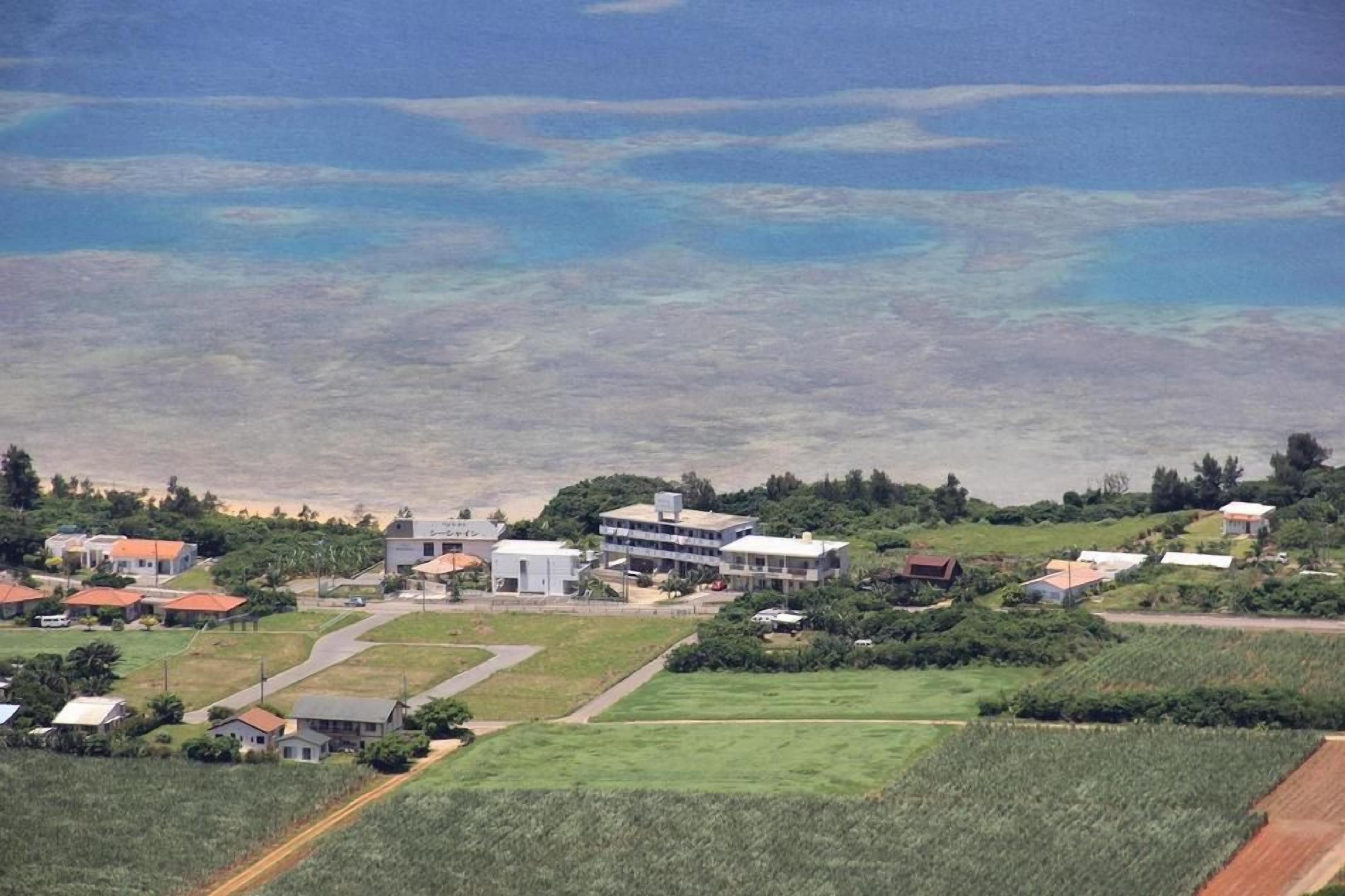 A coastal town with residential buildings, a main road, and a view of the sea.