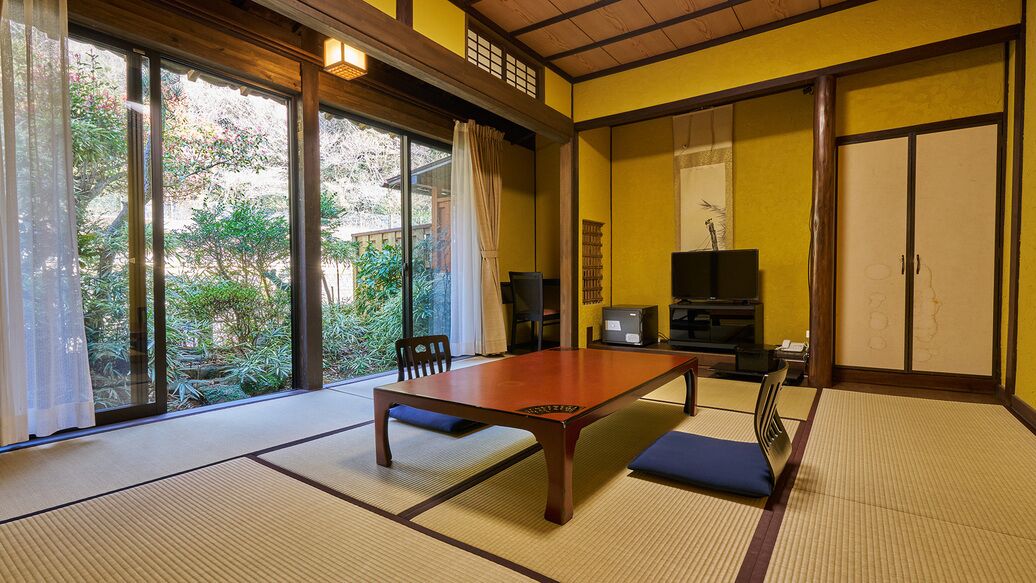 Een traditionele Japanse kamer met tatami vloerbedekking, een lage tafel en verschuifde deuren.
