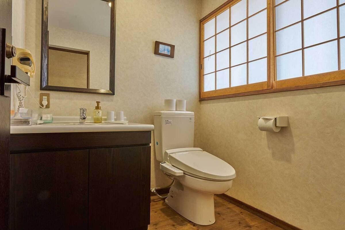 Un baño con inodoro, lavabo y espejo.