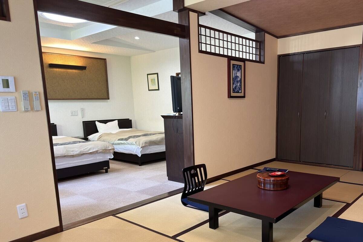 Una habitación de hotel con cama, escritorio, silla, televisión y armario.