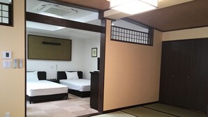 A traditional Japanese-style room with tatami flooring, two beds, a wardrobe, and a sliding door. - Yume-hotaru (Amakusa)