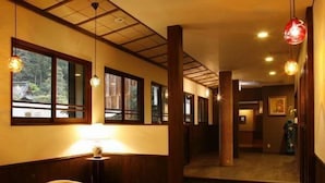 Um saguão de hotel com painéis de madeira, um balcão de recepção e uma área de estar.