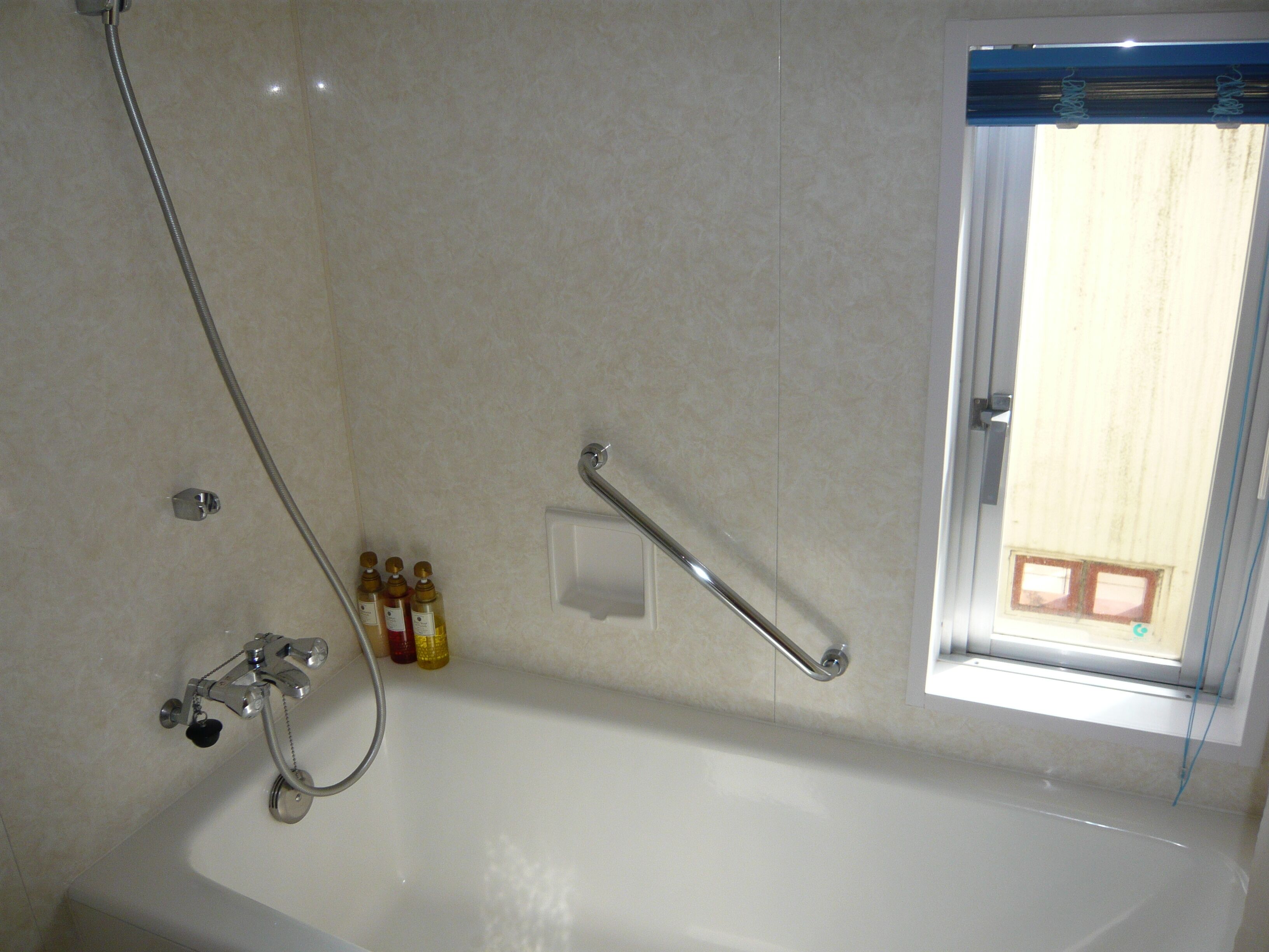 Une salle de bain avec une baignoire, une douche et une fenêtre.