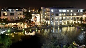 A multi-story hotel with a pool, outdoor seating, and a well-lit facade. - Garco Dragon Hotel 2 (Hanoi)