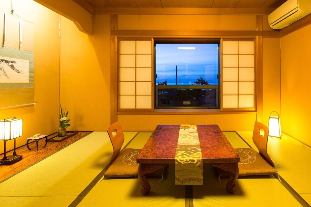 A traditional Japanese-style room with tatami flooring, a low table, and shoji screens.