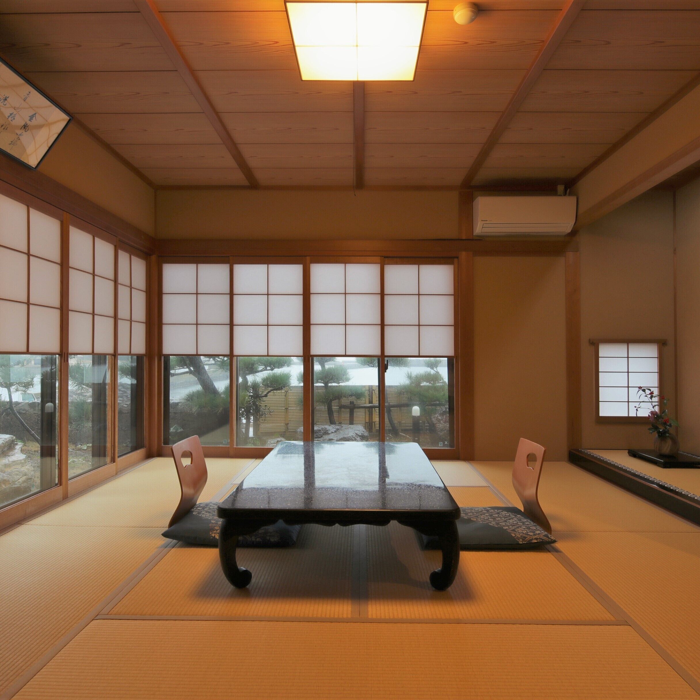A traditional Japanese room with tatami flooring, a low table, and sliding shoji doors.