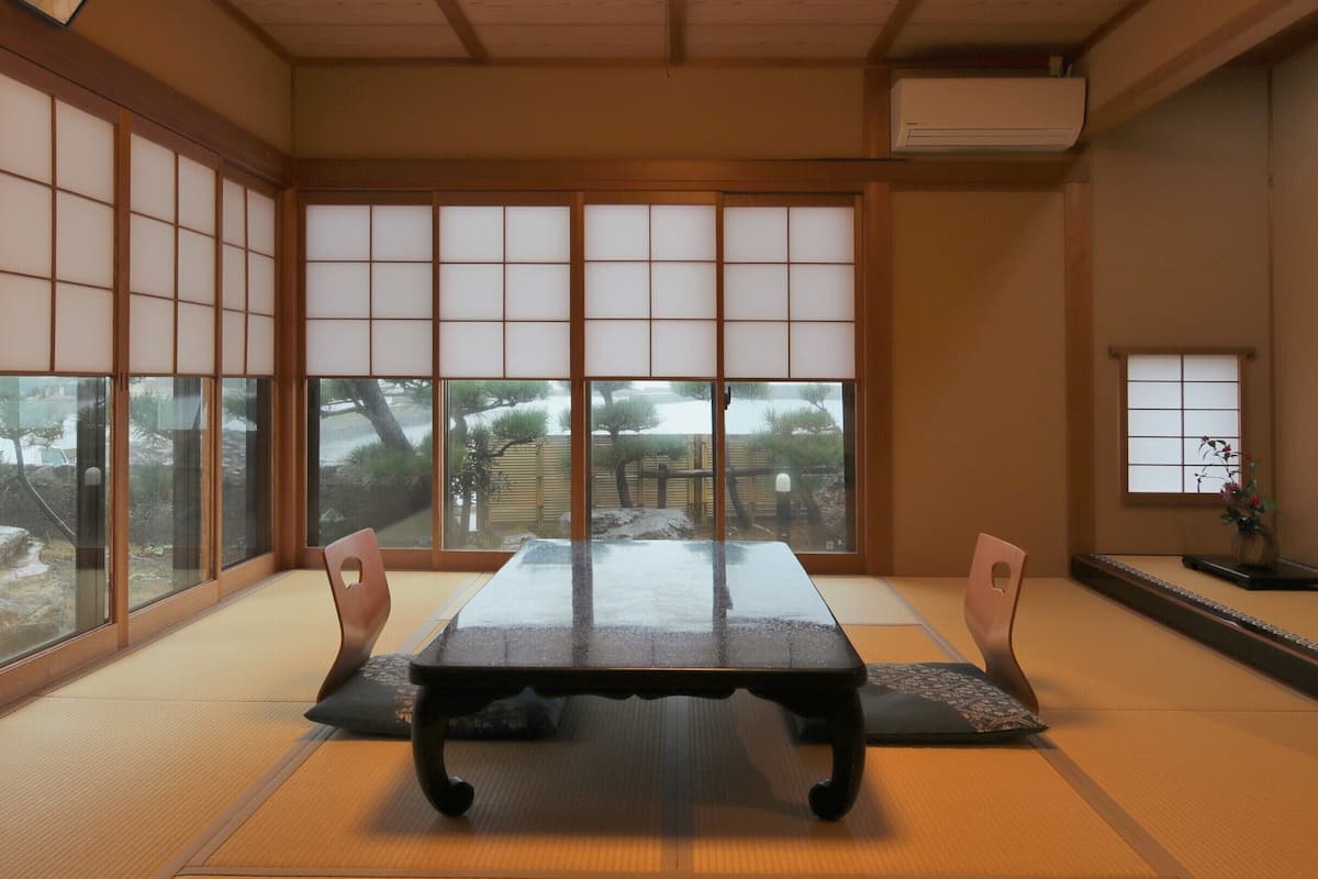 A traditional Japanese room with tatami flooring, a low table, and sliding shoji doors.