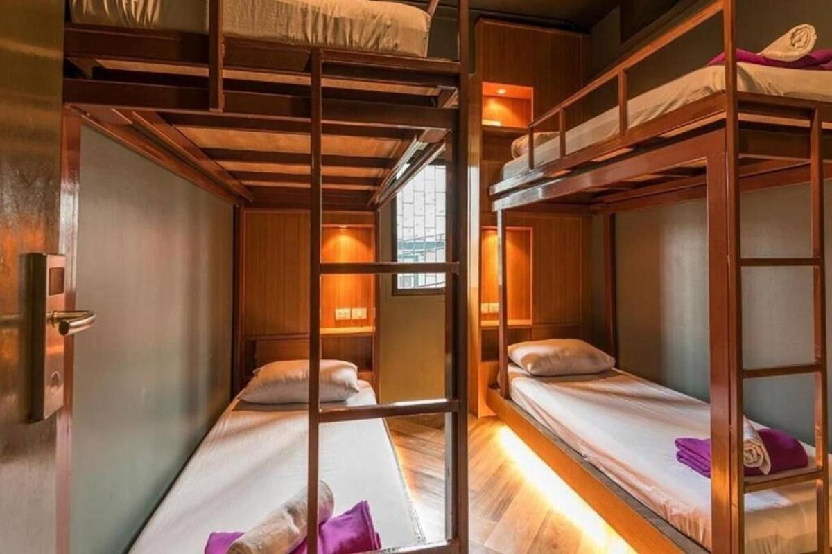 Una habitación con literas, paredes de madera y una ventana.