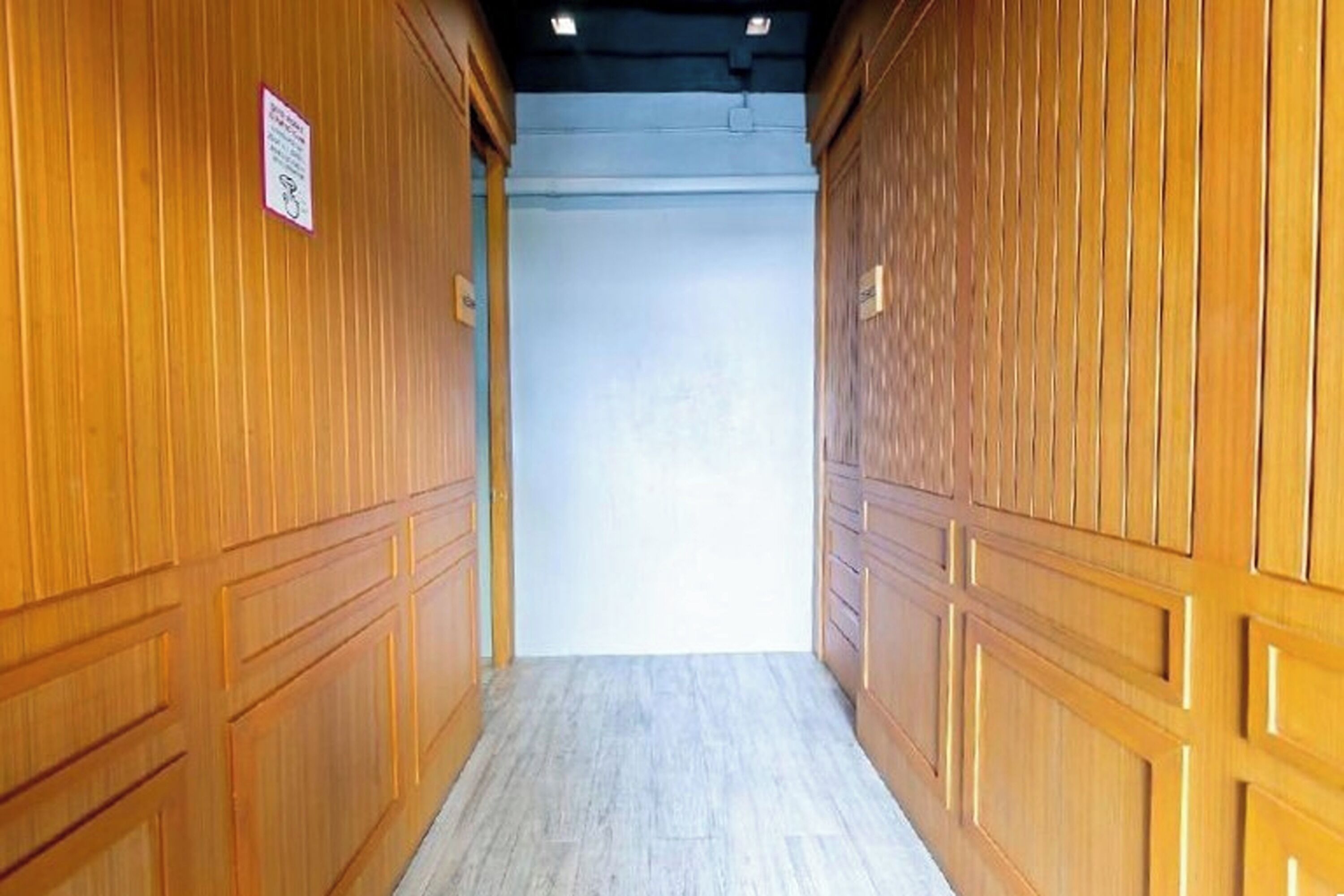 A hallway with wooden paneling and a light-colored floor.