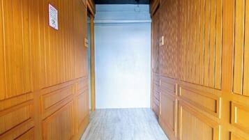 A hallway with wooden paneling and a light-colored floor.