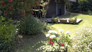 Une maison traditionnelle japonaise dotée d’un jardin, d’une terrasse en bois et d’un petit étang.