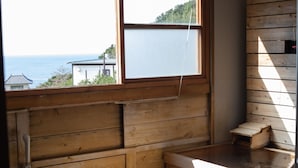 Interior de madeira com janela que dá para a água e edifícios.