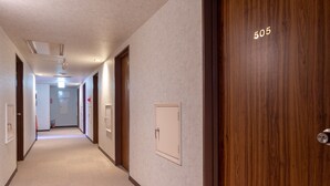 A hotel hallway with a carpeted floor, wooden doors, and a number 505 on one door. - Business Hotel YANAGI Kitakyushu Kokura (Kitakyushu)