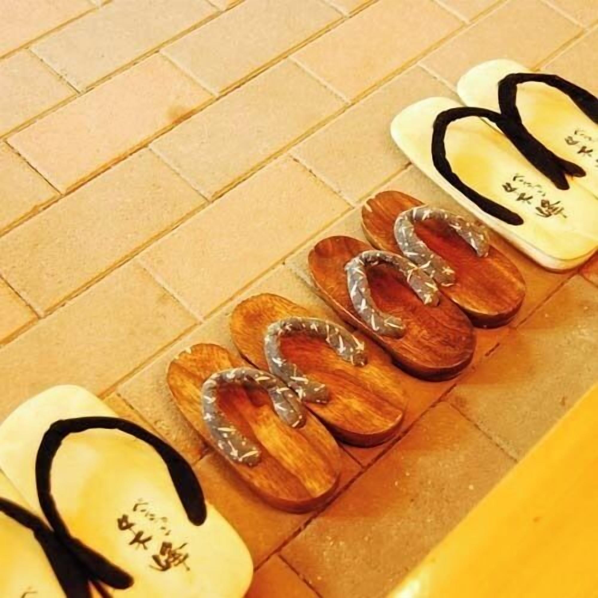 A row of flip-flops on a tiled floor.