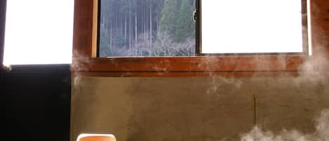 A room with a window, a wooden bench, and a white object on the bench.