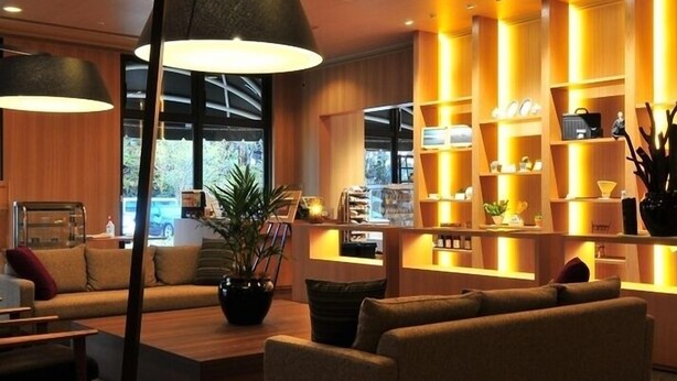 A modern living room with a sofa, coffee table, and a large floor lamp. - Kannabe Onsen Blue Ridge Hotel (TOYOKA SHI)
