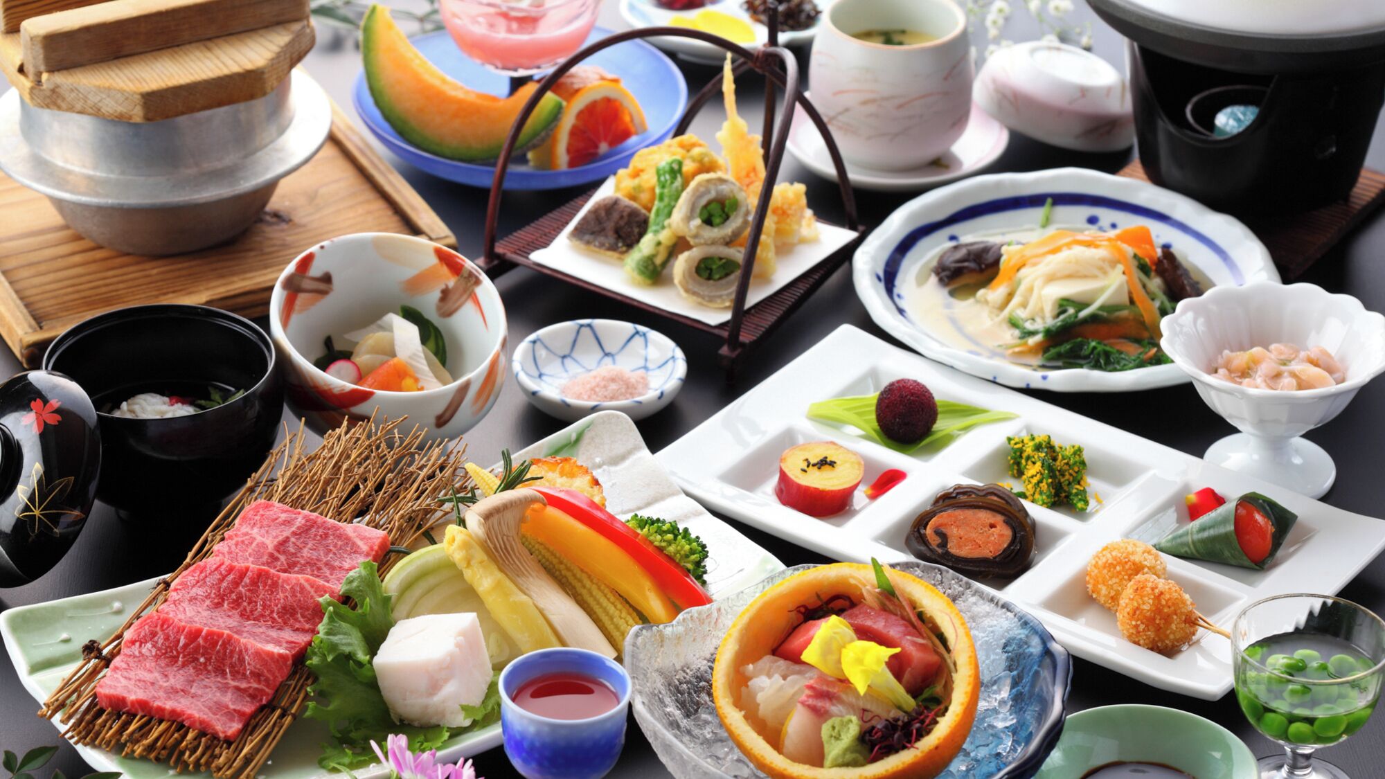 Una varietà di piatti e cibi su un tavolo, tra cui sushi, sashimi e altre specialità asiatiche.