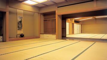 Una habitación con tatamis, puertas correderas, una obra de arte enmarcada y una estética japonesa tradicional.