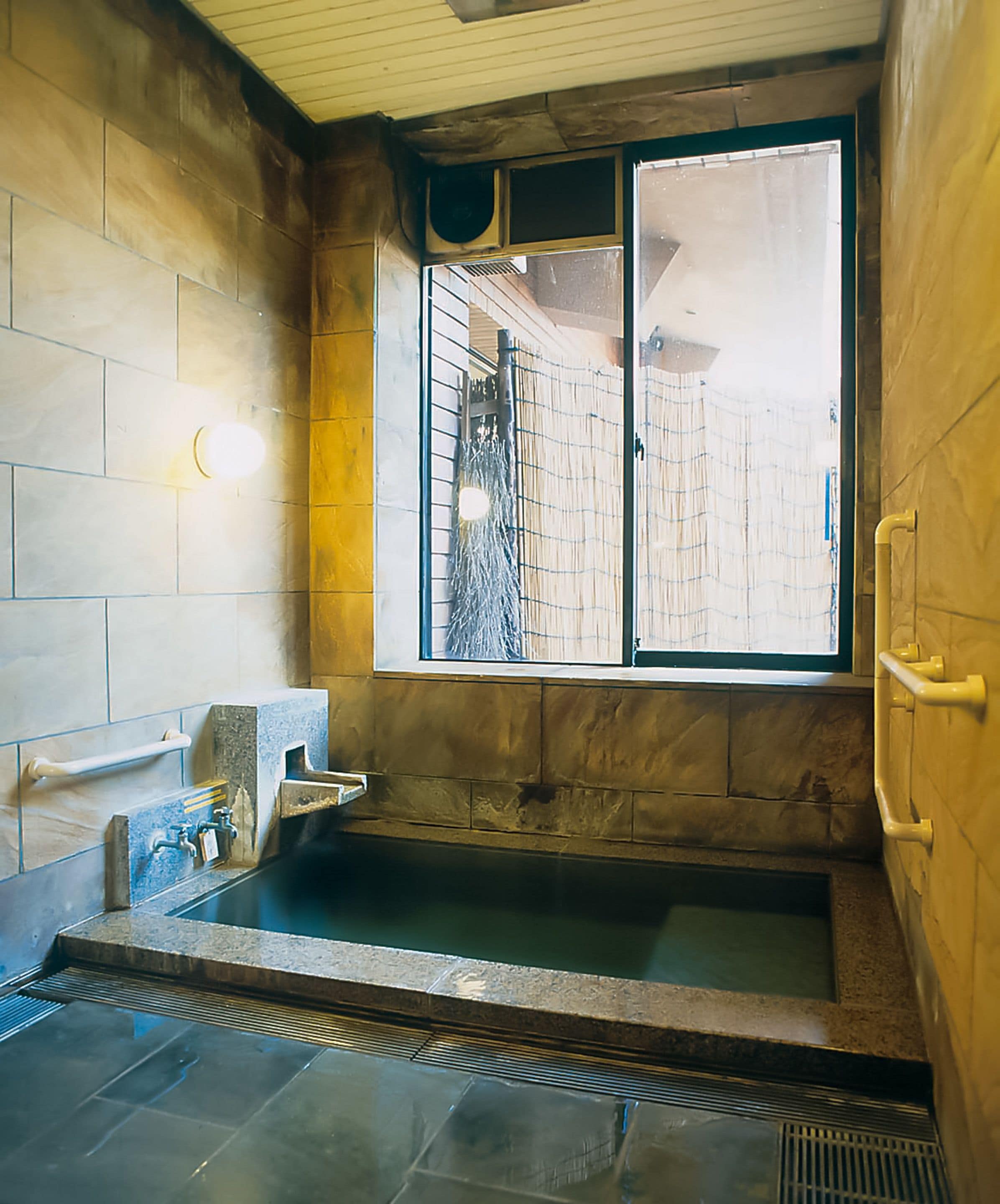 Un baño con un lavabo de piedra, una ventana con vistas y una zona de ducha.