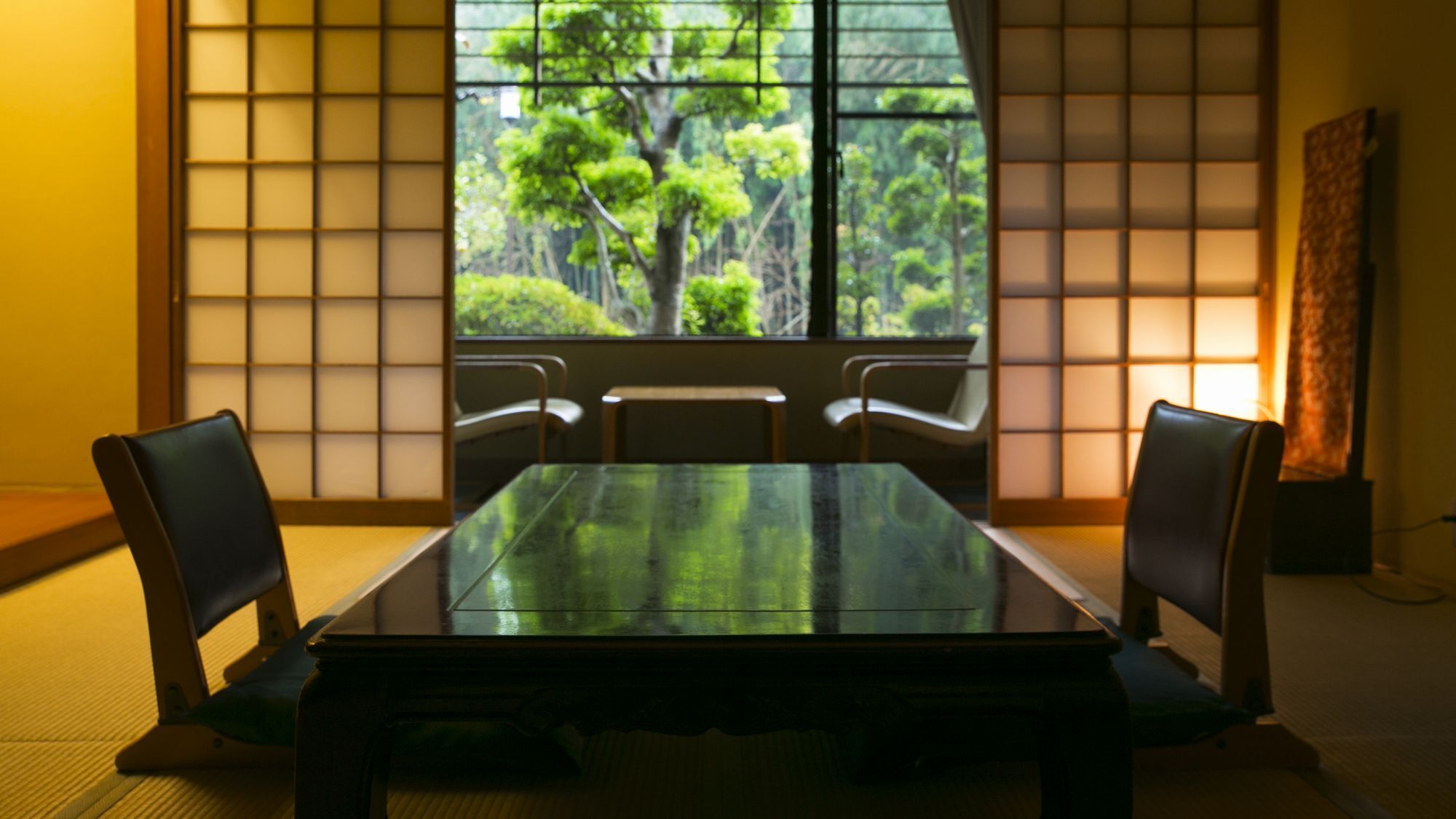 A traditional Japanese room with tatami flooring, a low table, and shoji screens.
