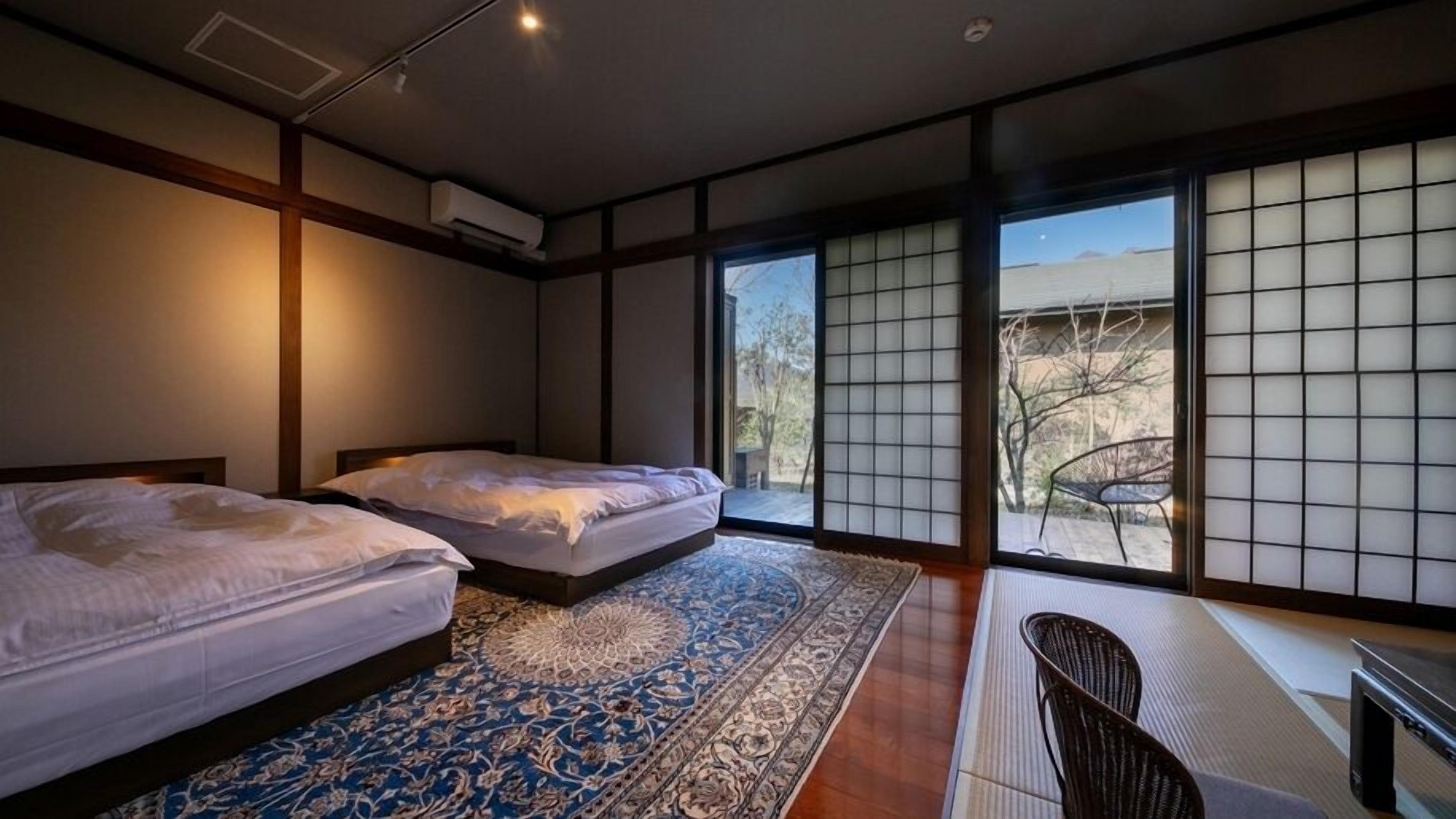 A hotel room with two beds, a large window with a view, and a traditional Japanese sliding door.