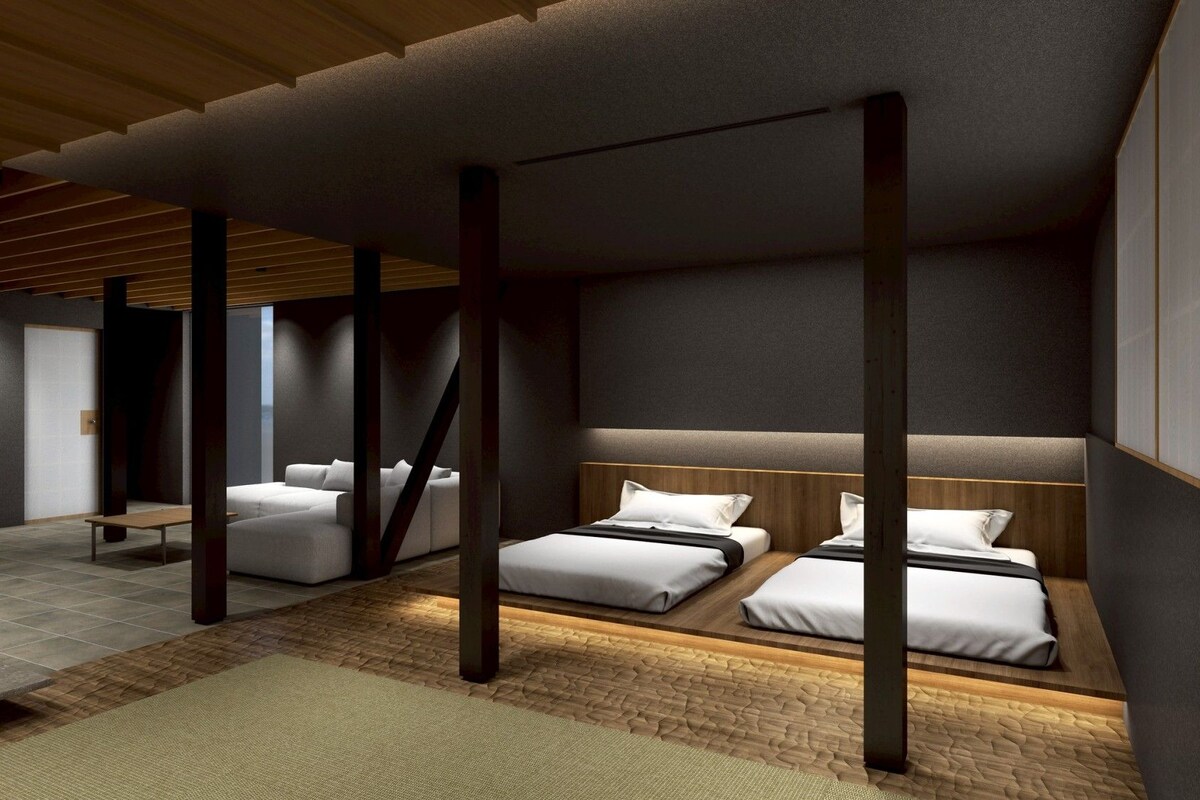 Camera d'albergo moderna con un letto grande, un divano più piccolo e una panca.