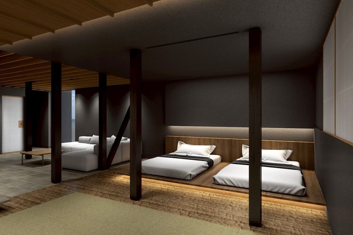 A modern hotel room with a large bed, a smaller sofa, and a bench.