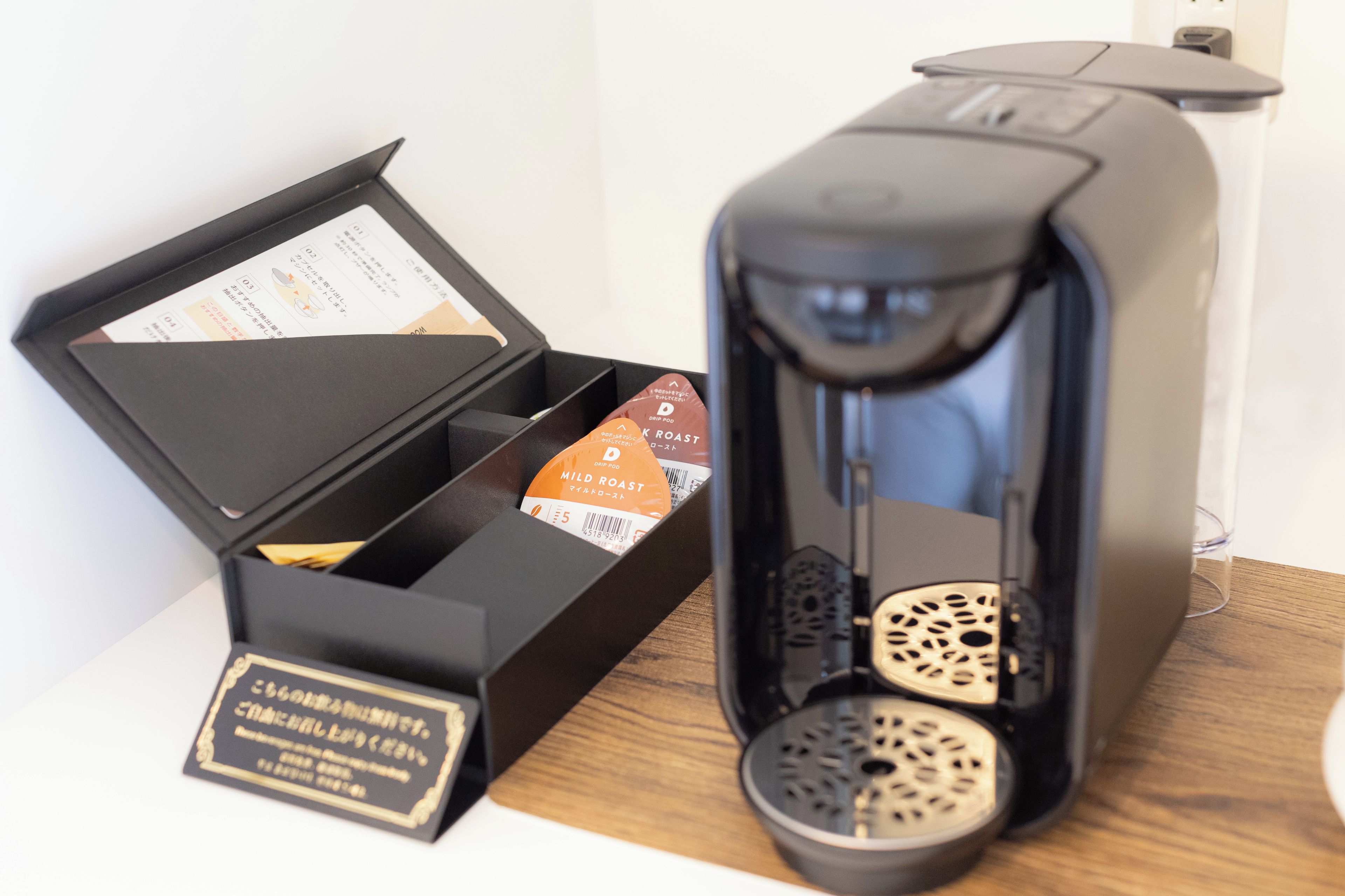 A coffee machine with a coffee pod and a label in a black box.