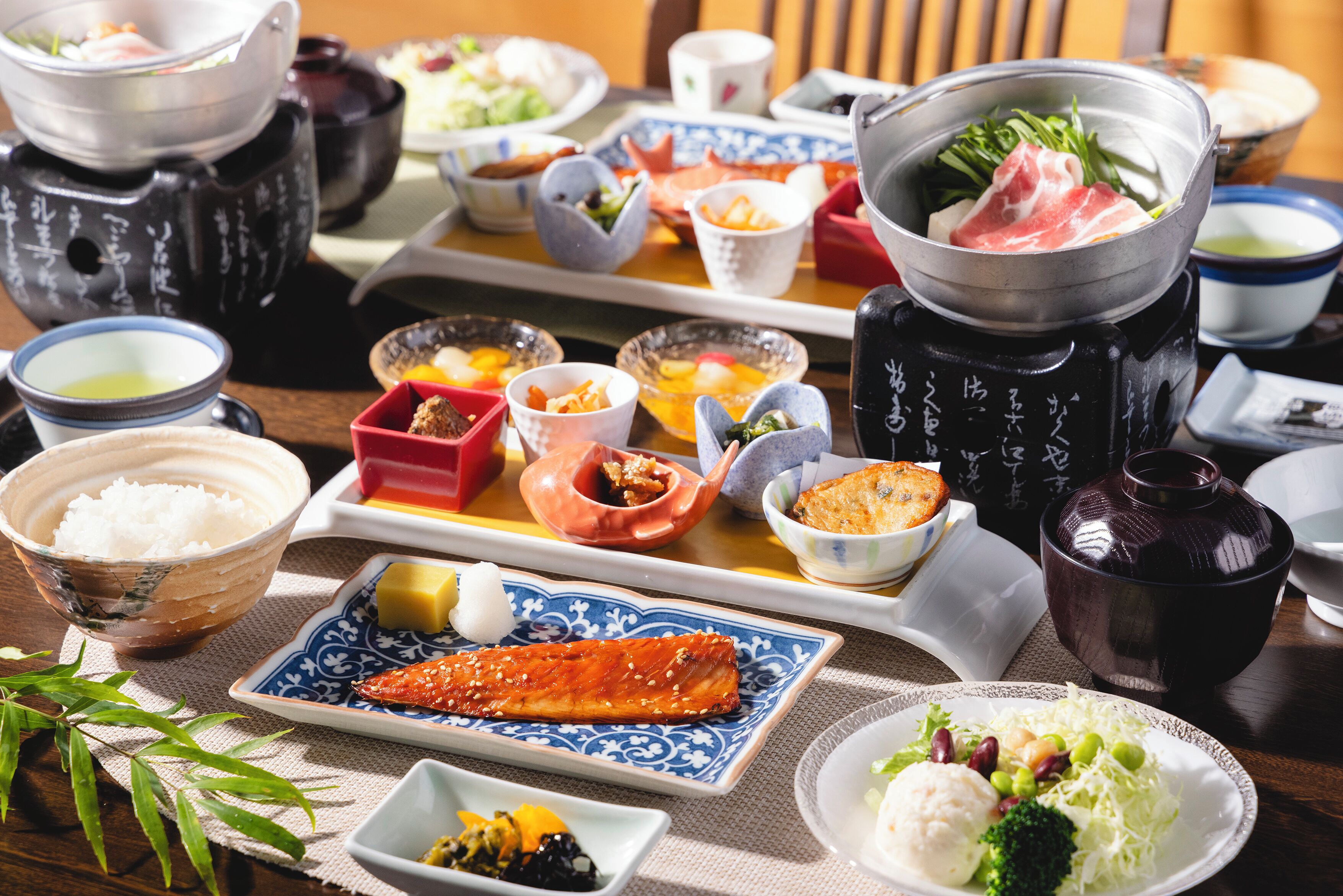 Un repas japonais traditionnel, composé de différents plats et d’un plat mijoté servi dans un récipient.