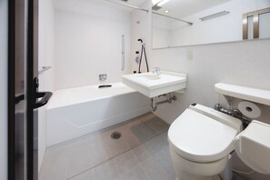 A modern bathroom with a bathtub, toilet, and sink.