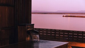 A wooden bench with a small waterfall feature in a wooden cabin setting.