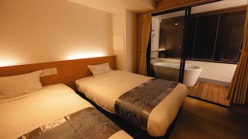 A hotel room with two beds, a wooden headboard, a large window with curtains, and a view of the outside.