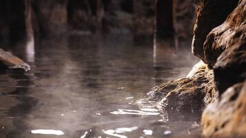 A natural hot spring with clear water and rocky formations.