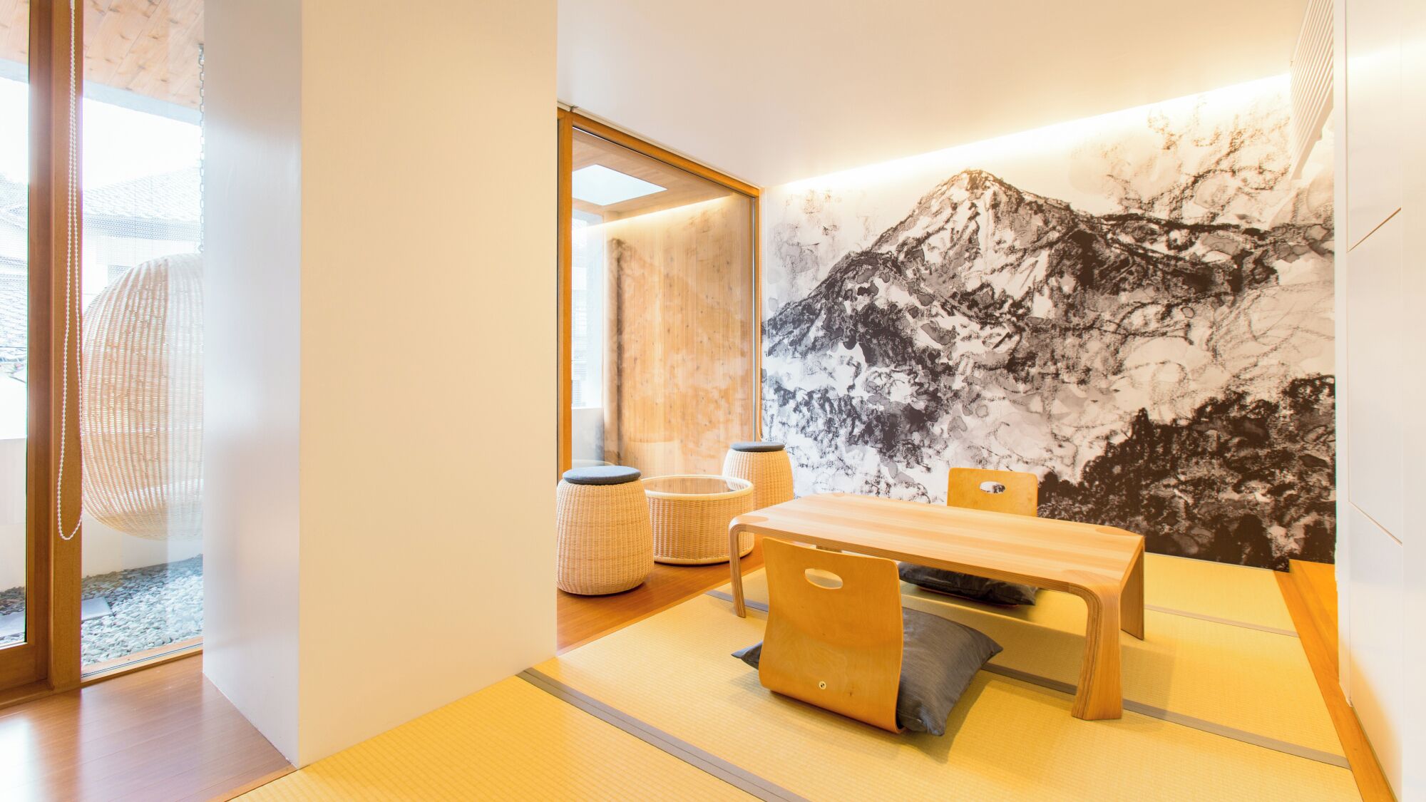 Een modern interieur met een houten tafel, stoelen en een groot muurschilderij.