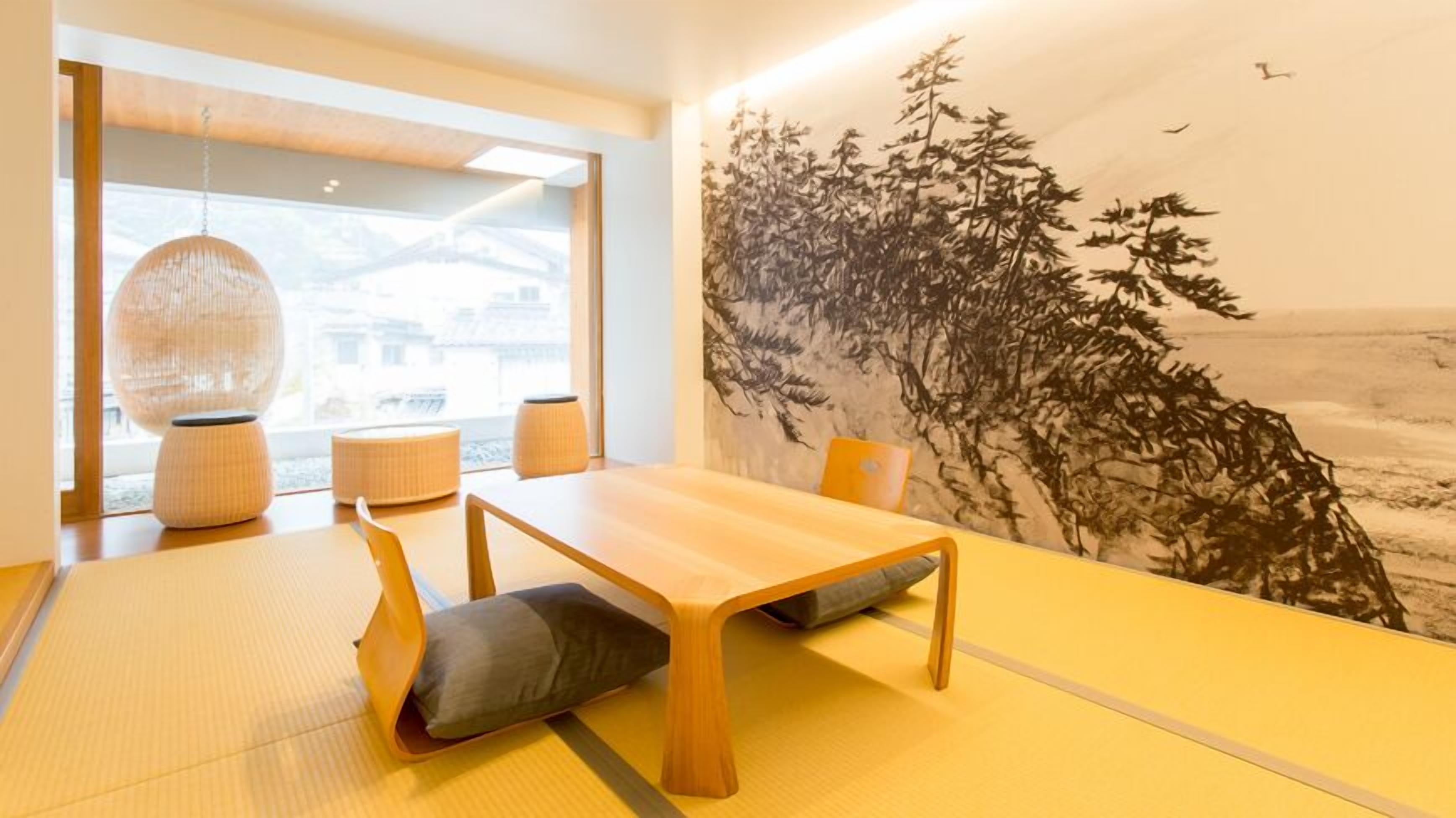 Una habitación japonesa tradicional con suelo de tatami, una mesa de madera baja y un gran cuadro mural.