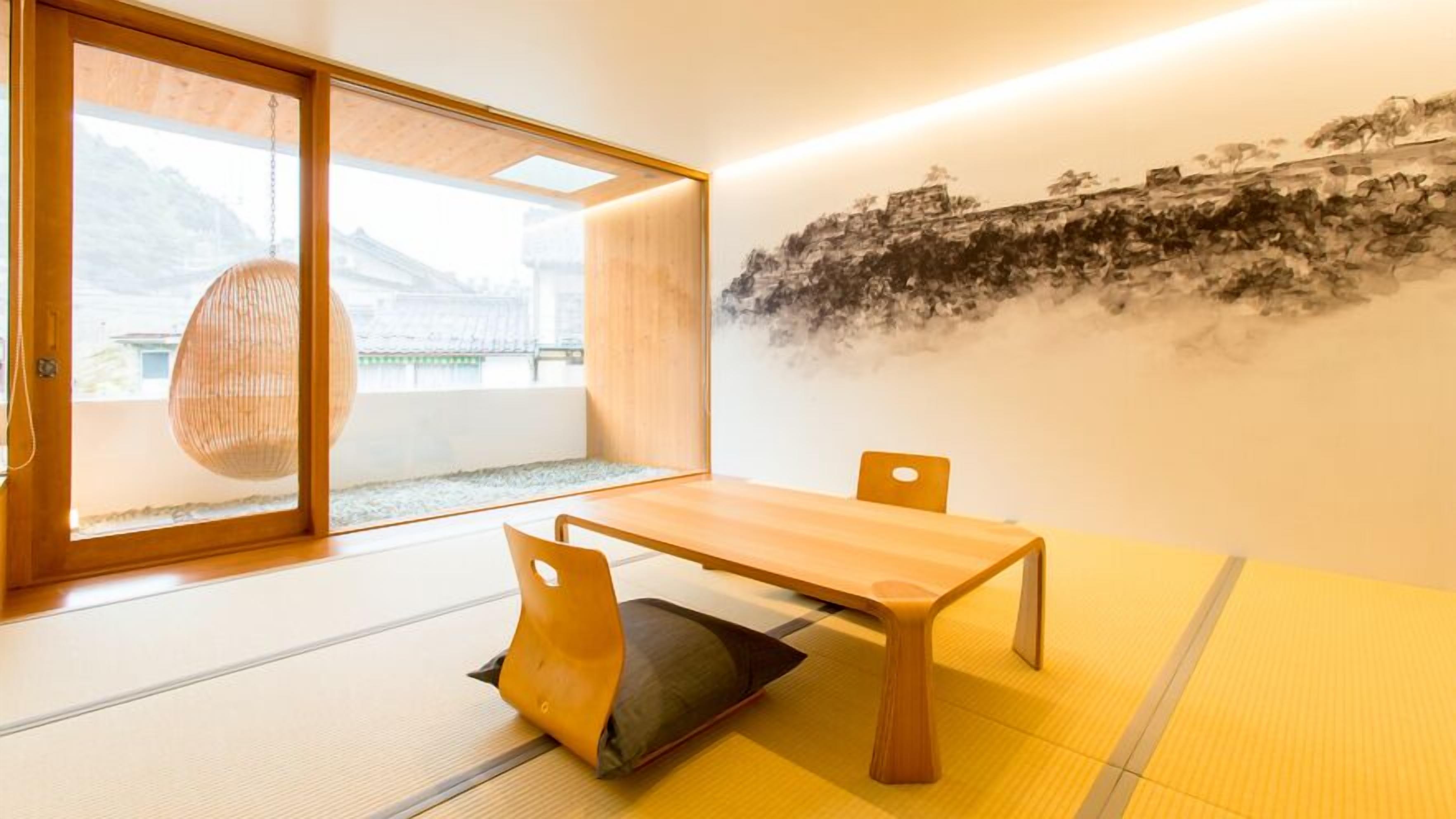 Una habitación japonesa tradicional con suelo de tatami, una mesa baja y sillas.